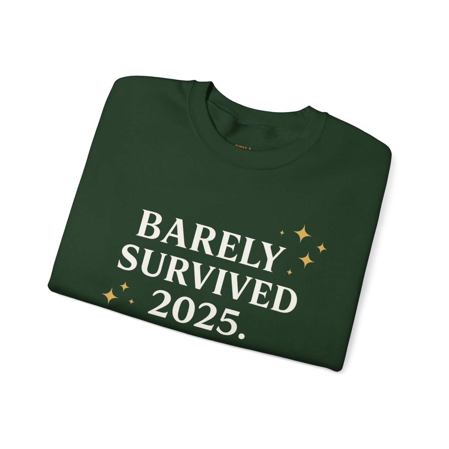 Green crewneck sweatshirt with white and gold text that reads “Barely Survived 2025. Mentally in 2026. Still Adulting: Holiday Edition.”