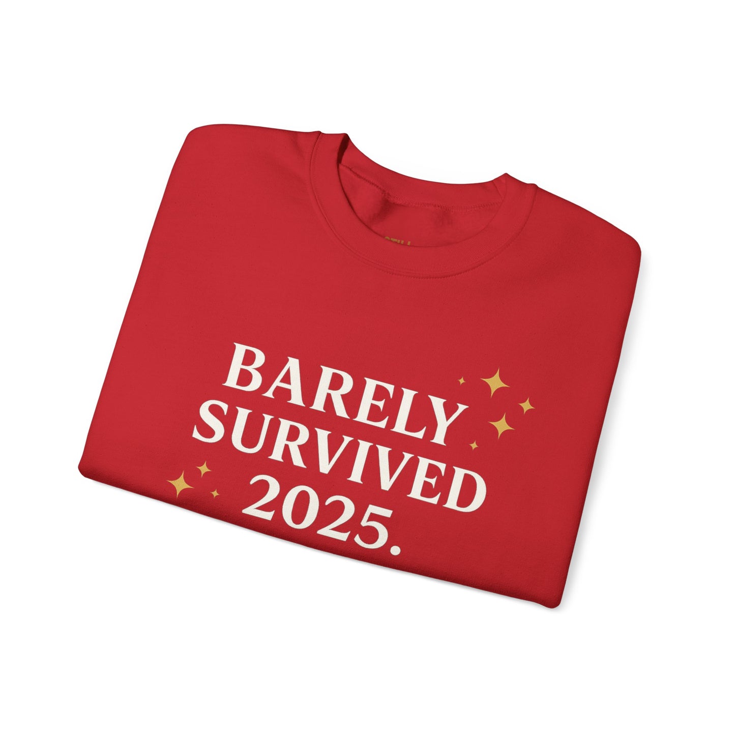 Red crewneck sweatshirt with white and gold text that reads “Barely Survived 2025. Mentally in 2026. Still Adulting: Holiday Edition.”