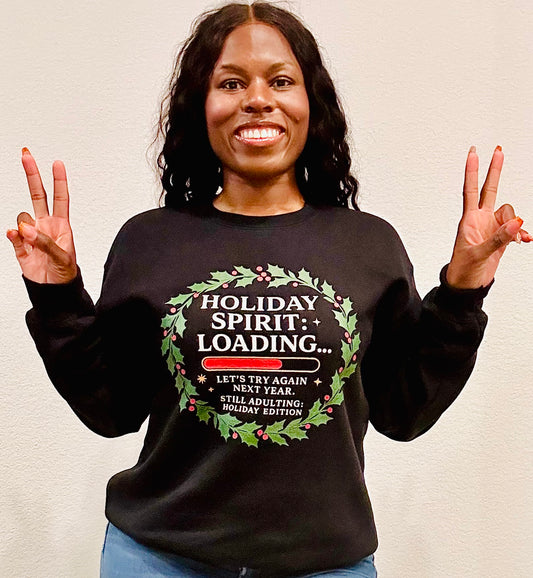“Woman wearing black holiday sweatshirt that says Holiday Spirit Loading”